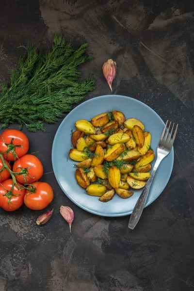 Patatas fritas, verdes, tomates y ajo en un fondo oscuro — Foto de Stock