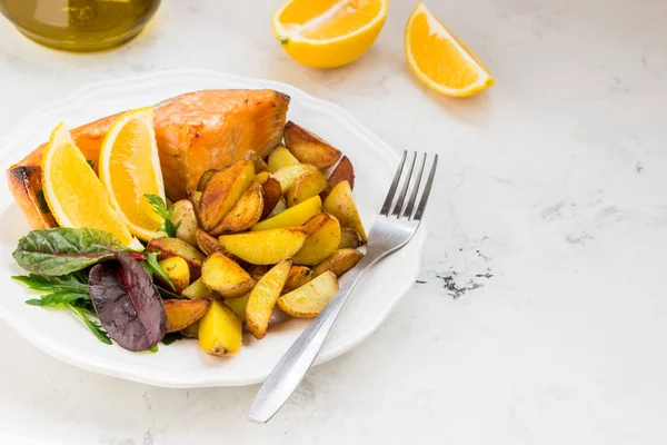 Patatas fritas con pescado y ensalada verde en un plato blanco — Foto de Stock