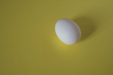 Beyaz yumurta bir sarı arka plan Üstten Görünüm