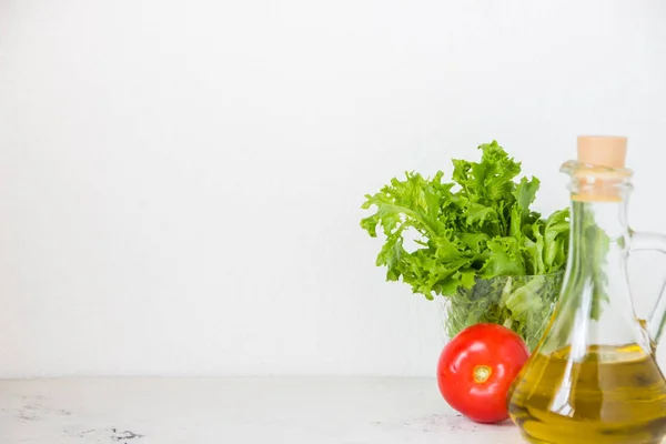 Olijfolie, groene salade sla en verse tomaat — Stockfoto