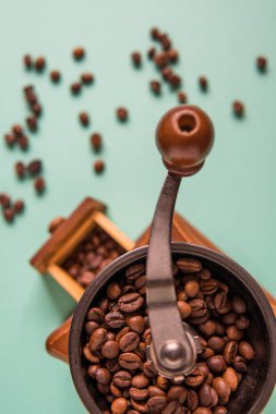 Kahve çekirdekleri bir el Kahve değirmeni bir ihale yeşil bac üzerinde