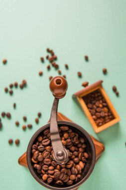 Kahve çekirdekleri bir el Kahve değirmeni bir ihale yeşil bac üzerinde