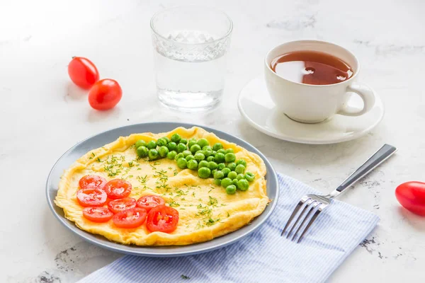 Tortilla con guisantes verdes y tomates cherry. Desayuno con proteínas —  Fotos de Stock