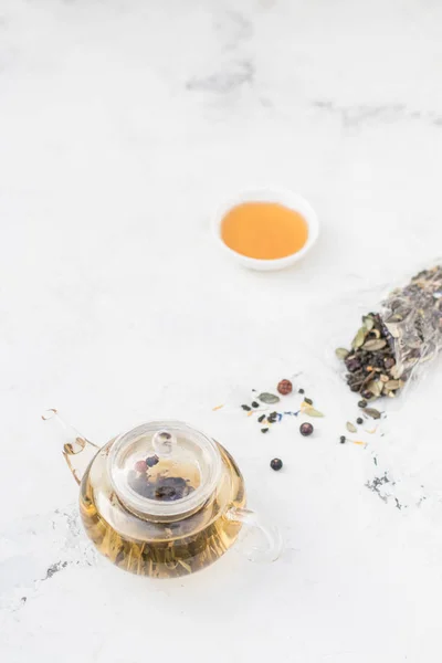 Teh dalam teko gelas. Teh herbal dengan buah beri dan madu — Stok Foto