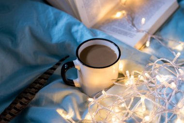 Yatakta kahve bardağı ve çelenk. Atmosferik Hygge tarzı. Rahat w