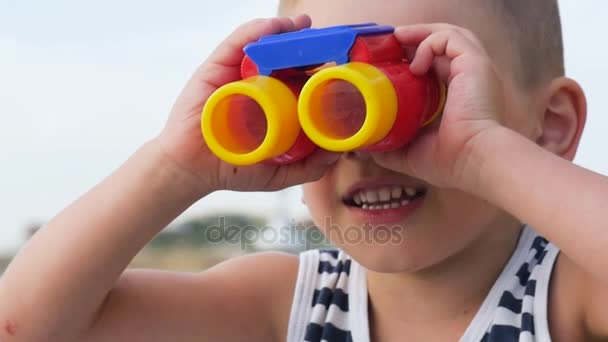 Niño feliz mirando lejos a través de los prismáticos — Vídeos de Stock