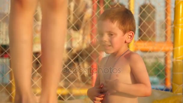 Adorável menino e menina pulando no trampolim ao ar livre — Vídeo de Stock