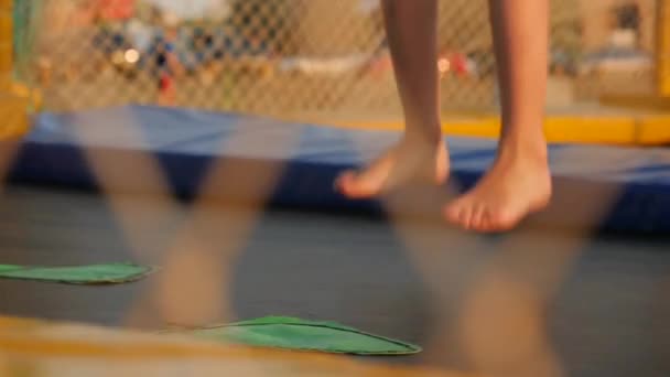 Benen van kinderen lopen en springen op de trampoline — Stockvideo