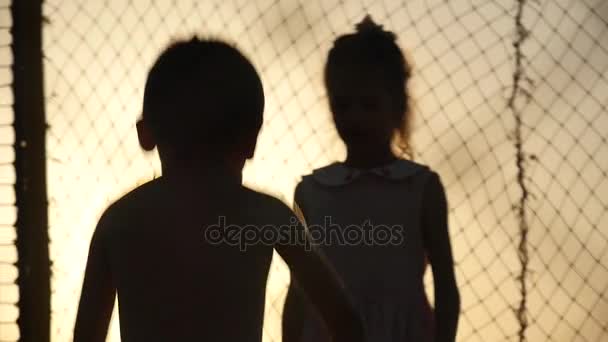 Niños saltando en el trampolín al atardecer — Vídeos de Stock