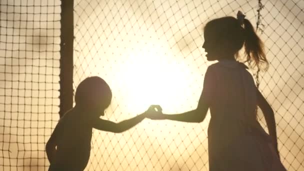 Two kids jumping on the trampoline at sunset — Stock Video