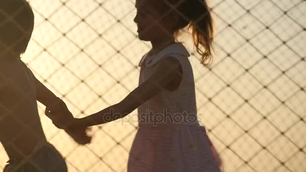 小さい子供が海の夕日の背景にトランポリンで遊んで — ストック動画