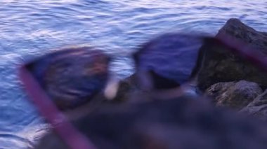 Deniz arka plan üzerine bir taş üzerinde moda güneş gözlüğü yalan