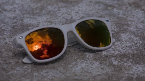 Paisaje nublado con sol brillante que brilla reflejado en gafas de sol — Vídeos de Stock