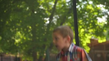 sevimli küçük çocuk Kareli gömlekli bir trambolin üzerinde atlama