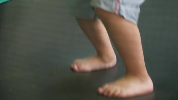 Nogi, mały chłopiec, skoki na trampolinie — Wideo stockowe
