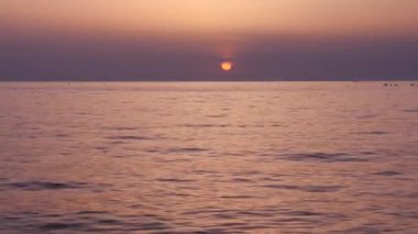 Yavaş yavaş dalgalar haddeleme ile sahilde güzel gün batımı