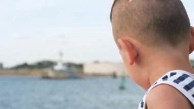 gökyüzü ve deniz arka plan üzerinde denizci çizgili gömlekli komik küçük çocuk