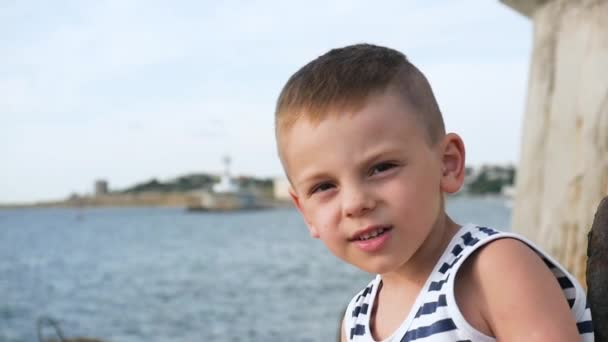 Glad liten pojke i sailor stripes skjorta på himmel och hav bakgrund — Stockvideo