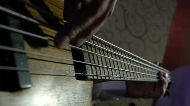 Бас-гитарист крупным планом играет на басу пальцами — стоковое видео