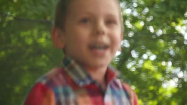 Schattig kindje in een plaid shirt springen op een trampoline slow motion — Stockvideo