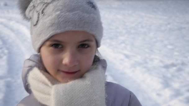 Retrato niña en el fondo de la tierra cubierta de nieve — Vídeos de Stock