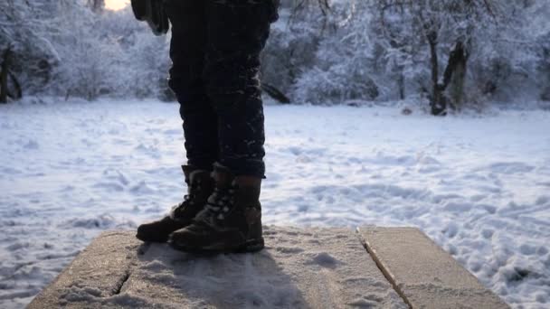 Kleine jongen gaat op een houten tafel in de winter — Stockvideo