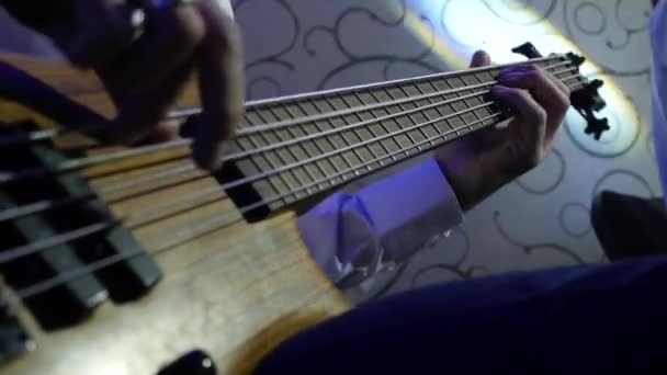 Muž si hraje basová kytara rockový koncert. Closeup. — Stock video