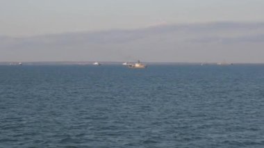 Kerch Boğazı 'ndaki küçük yüzen gemi, Karadeniz' in su bölgesinde paralel bir rotada yüzen gemiden çekim yapıyor..