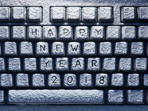 Desktop keyboard covered with white snow with title happy new year 2018 — Stock Photo, Image