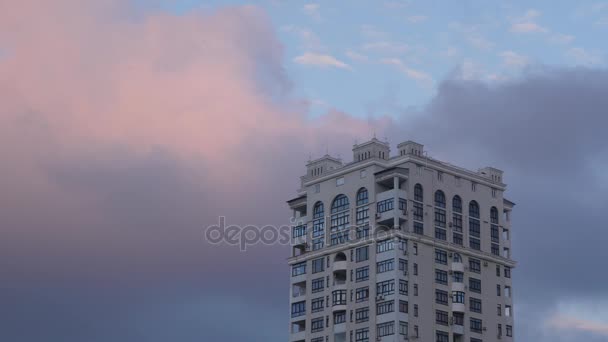 高层建筑在天空背景下有美丽的移动的云彩在日落 晚上看法一座摩天大楼与一朵令人惊叹的云彩在天空 — 图库视频影像