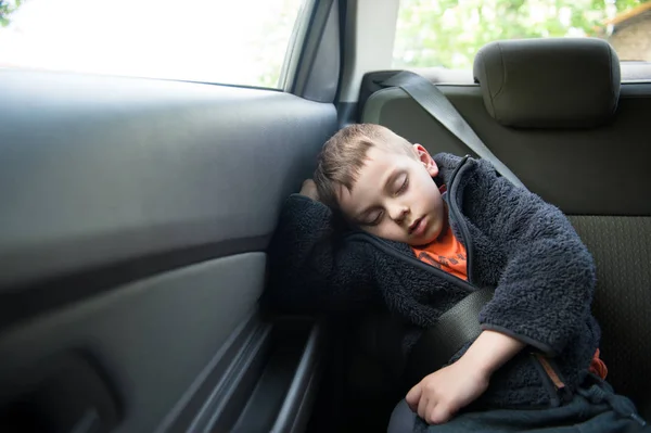 Adorable enfant endormi sur le siège arrière de la voiture avec ceinture de sécurité — Photo