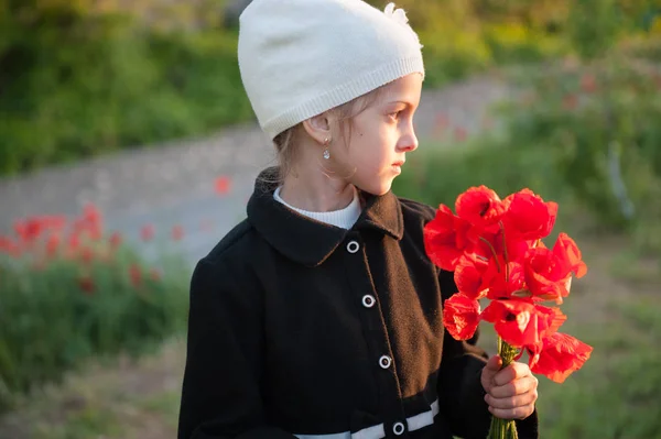 Menina pequena bonito com buquê de flores no pôr do sol da primavera — Fotografia de Stock