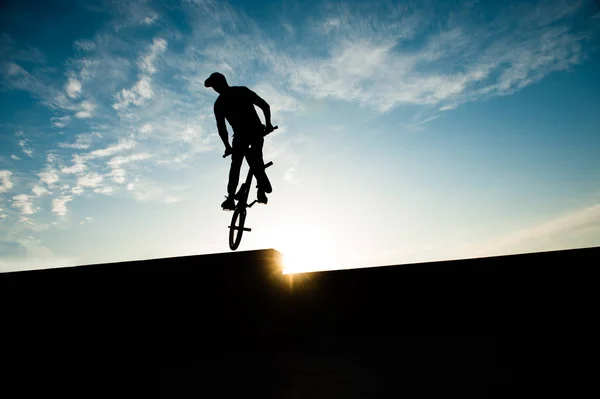 Silhouet van een fietser springen op de fiets op avondrood achtergrond — Stockfoto