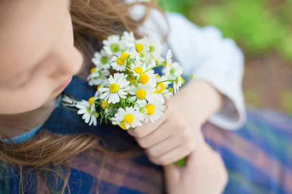 Menina segurando um buquê de margaridas na primavera — Fotografia de Stock