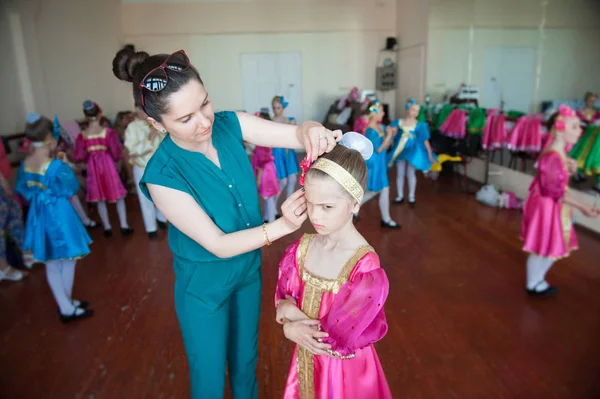 Mãe prepara sua filha infeliz para um concerto na escola de dança — Fotografia de Stock