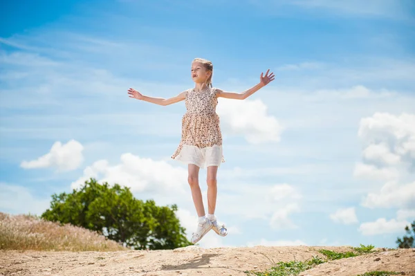 sıska güzel dansçı kız elbiseli karşı mavi gökyüzü yaz aylarında yüksek atlama