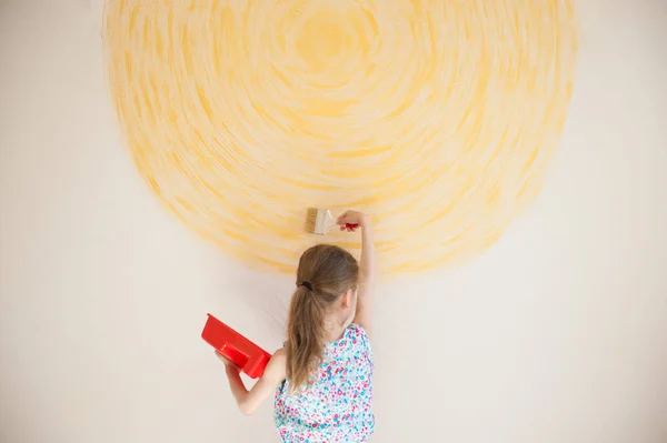 Kleines süßes kaukasisches Mädchen malt gelben Kreis an Hauswand — Stockfoto