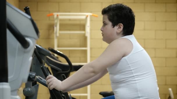 Obesidad Niño Pequeño Entrenamiento Bicicleta Estacionaria Gimnasio Perder Peso Concepto — Vídeo de stock