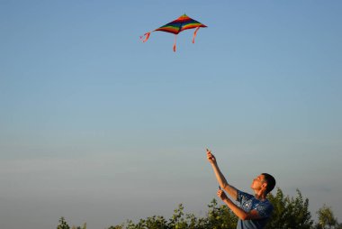 yakışıklı aktif genç erkek renkli uçurtma havada yaz gün batımında denetleme