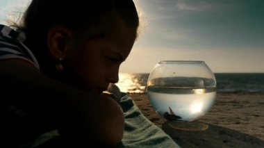 Tatlı küçük kız iskele Plajı ve Balık Akvaryum açık bakarak yatıyor. Konsept tatil.