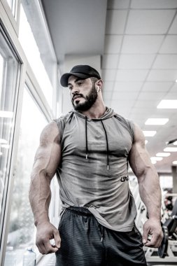güçlü sakallı adam spor salonunda antrenman yapıyor.