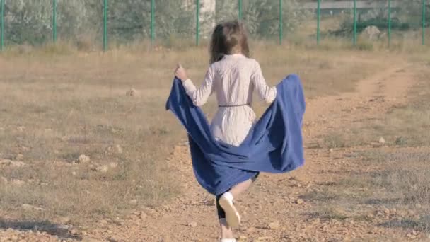 一个奇怪的身材矮小的小女孩 手里拿着毛巾 从贫民窟里跳到禁区附近 贫困被遗弃儿童受害者经济危机 — 图库视频影像