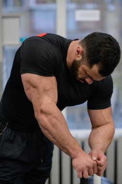 Spor zihin motivasyonu konsepti. Spor molası sırasında spor salonunda eğilen sakallı, güçlü, yorgun adam konsepti.