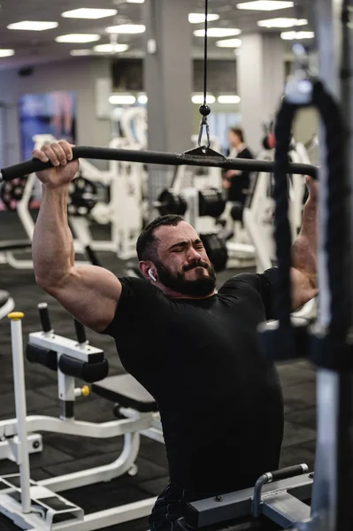 strong young bearded man training in gym