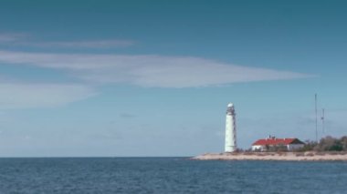 beautiful old white Lighthouse seascape where clouds are animated like a time lapse, but the ocean, waves and shoreline are motionless. Can be used in a loop for endless playing Cinemagraphs.