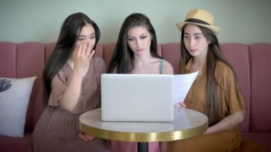 three girlfriend talk social network on Tablet Computer while Sitting Coffee Shop. concept remote communication with people. shopping online store.