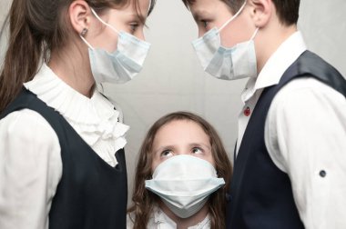 Coronavirus COVID-19 2019-NCoV salgını üç hasta aile çocuğu okul üniforması giyip birbirlerine bakıyorlar.