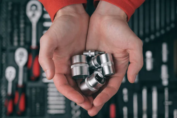 maintenance automotive garage concept of human mechanic hands wearing red clothes holding chrome sockets on background of tool box kit for car auto repair
