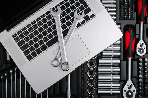 Service maintenance silver chrome wrench and spanner lying on laptop computer on toolbox with pro car auto tools for fix repair — Stock Photo, Image