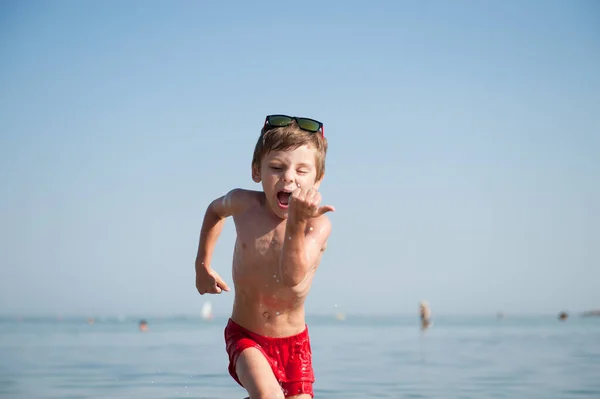 Bambino Attivo Indossando Occhiali Sole Pantaloncini Rossi Esecuzione Acqua Mare — Foto Stock